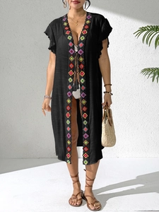 Detail of black beach cover-up with colorful crochet lace trim and tassel tie front