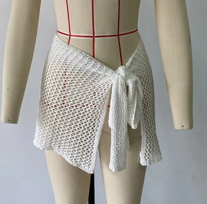 Vue détaillée de la texture en crochet blanc et du lien latéral de cette jupe de plage