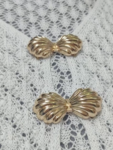 Dettaglio delle fibbie decorative dorate a forma di conchiglia in metallo a rilievo