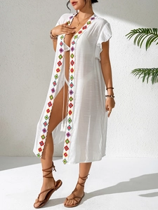 Detail of bohemian beach cover-up with colorful embroidery and ruffled cuffs