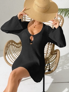 Nahaufnahme von schwarzem Häkel-Strandkleid mit tiefem V-Ausschnitt und Lochmuster-Detail