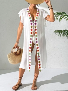 Detailed close-up of white bohemian beach cover-up with colorful diamond embroidery