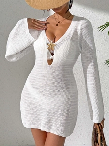 Detailansicht der goldenen Seestern-Brosche und Häkelstruktur am weißen Strandkleid