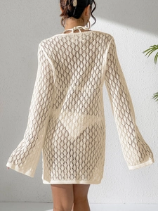 Dettaglio posteriore di un copricostume da spiaggia in crochet crema con trama a rete