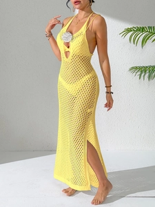 Detail of yellow crochet knit dress featuring white floral accents and a side leg slit