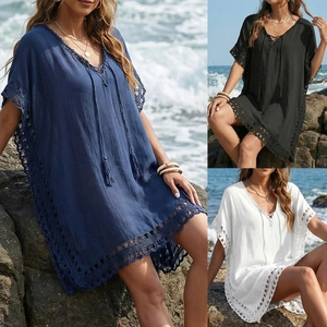 Detail of crochet lace hem and tassel tie V-neck on loose beach cover-up dress