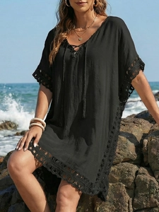Detail of crochet lace hem and deep V-neck lace-up on black beach cover-up dress