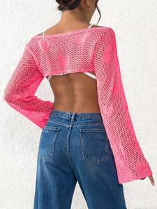 Detail of hot pink crochet shrug featuring heart hollow-out knit and open back design