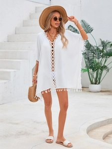 Détail de la robe de plage bohème blanche avec col en V, crochet et finitions à franges