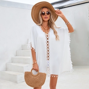 Détail de la robe de plage blanche bohème avec dentelle au crochet et pompons
