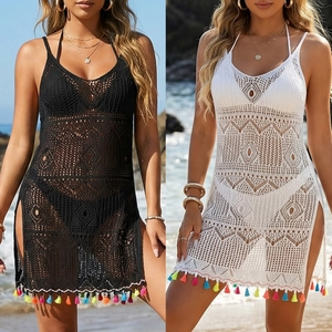 Detail of crochet beach cover-up with hollow wave pattern and colorful fringe hem