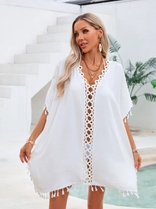 Robe de plage blanche style boho avec détails en dentelle ajourée et ourlet à franges