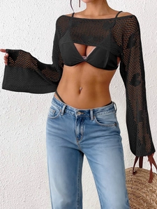 Detail of black crochet shrug with heart hollow pattern and flared sleeves for beachwear