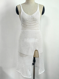 Close-up of white crochet beach cover-up showing hollow geometric knit and slit detail