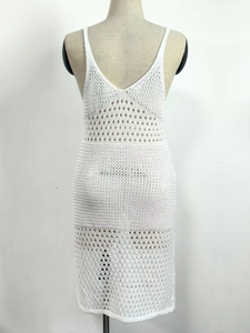 Detail of white crochet beach dress with intricate hollow-out knitting and V-neckline