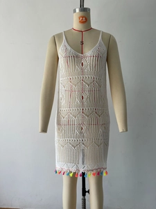 Detailed view of white crochet dress featuring hollow-out patterns and colorful fringes