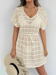Détails de la robe de plage beige au crochet avec motifs floraux et taille à cordon serrage