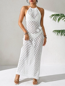 Dettaglio del vestito lungo bianco all'uncinetto con fiori applicati e trama traforata