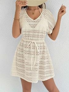 Détail de robe de plage au crochet montrant le col en V et la taille à cordon réglable