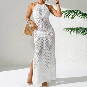 Détail d'une robe de plage blanche au crochet avec motif losanges et fente latérale haute