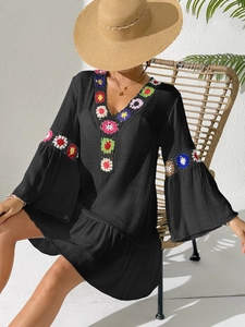 Bohemian black V-neck mini dress with colorful crochet floral trim and ruffle details