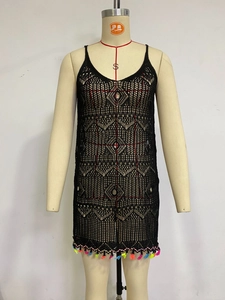 Detail of black crochet beach cover-up with colorful fringe hem and hollow geometric patterns