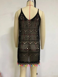 Detailed view of black crochet knit beach dress with vibrant colorful fringe and V-neckline