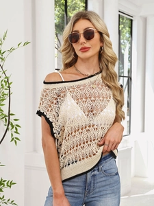 Detail of hollow knit vest with black contrast trim and intricate crochet pattern