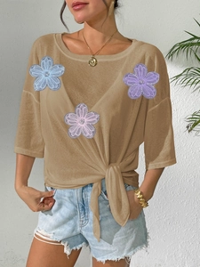 Detail of khaki tie-waist top with three-dimensional lace flower appliques and bow knot