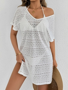 Close-up of white crochet beach cover-up featuring geometric knit patterns and V-neckline