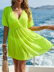 Detail of neon green beach cover-up with deep V-neck and high waist on a sunlit yacht