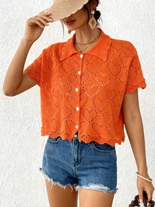 Detail of orange heart hollow knit cardigan with white buttons and collar