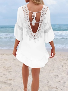 Détail du cache-maillot blanc au crochet avec dos nu, pompons et manches à volants