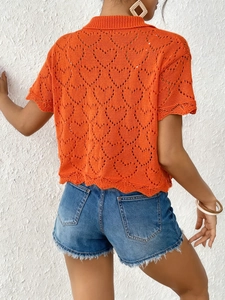 Close-up of orange hollow-out knitted heart pattern and polo collar detail