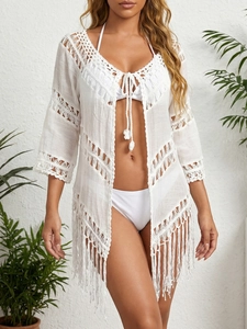 Détail d'un cache-maillot de plage en crochet blanc avec motifs ajourés et franges