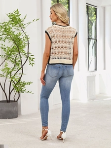 Hollow-out knit vest with black contrast trim and light blue skinny jeans back view