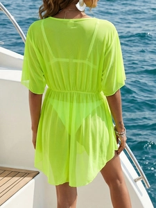 Detail of neon yellow mesh beach cover-up with elastic high waist on a yacht deck