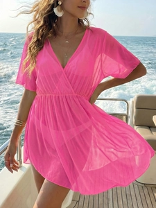 Hot pink mesh beach cover-up with deep V-neck and cinched waist on a yacht