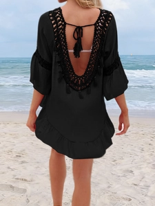 Détail du cache-maillot de plage en crochet noir avec col en V profond et détails à glands