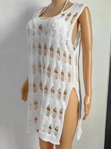 Detail of white knit beach cover-up featuring intricate hollow out design and high side slit