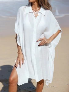 Detail of white semi-transparent beach cover-up with polo collar and button-up front