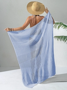 Détail du paréo de plage au crochet bleu clair montrant la texture ajourée