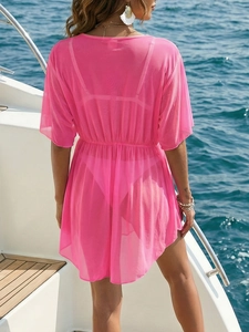 Pink sheer mesh beach cover-up with waist tie shown from the back on a boat deck