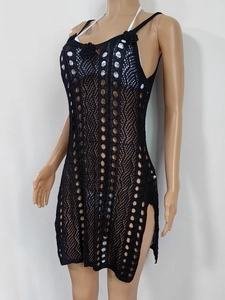 Detail of black crochet beach cover-up with floral neck appliqué and open knit texture