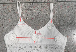 Détail de la robe crochet blanche montrant l'emplacement des fleurs 3D et la maille