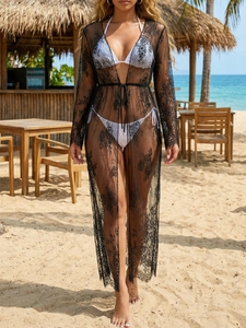 Detailed macro view of delicate black lace fabric and floral embroidery on a beach cover-up