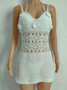 Détails d'une robe au crochet blanche avec fleurs 3D et motifs en tricot ajouré