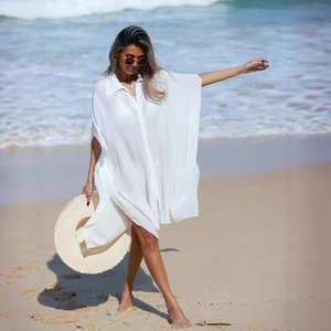 Detailed texture of white sheer beach cover-up shirt with loose sleeves and lapel collar