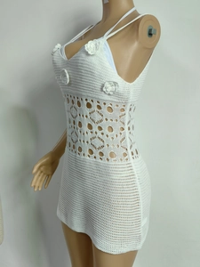Détail de robe de plage au crochet blanc avec fleurs 3D et motifs en maille ajourée