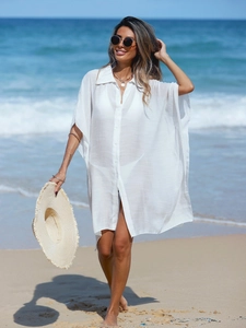 Detail of white linen-style beach cover-up fabric with textured button-down front